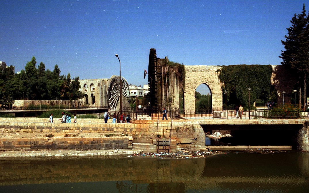 حماة 1985- ناعورة الجسرية وخلفها ناعورة المأمورية ثاني أكبر ناعورة في المدينة