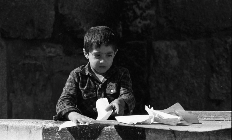 طفل في دمشق القديمة يصنع زوارق من ورق عام 1987م (2)