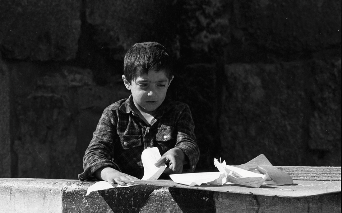 طفل في دمشق القديمة يصنع زوارق من ورق عام 1987م (2)