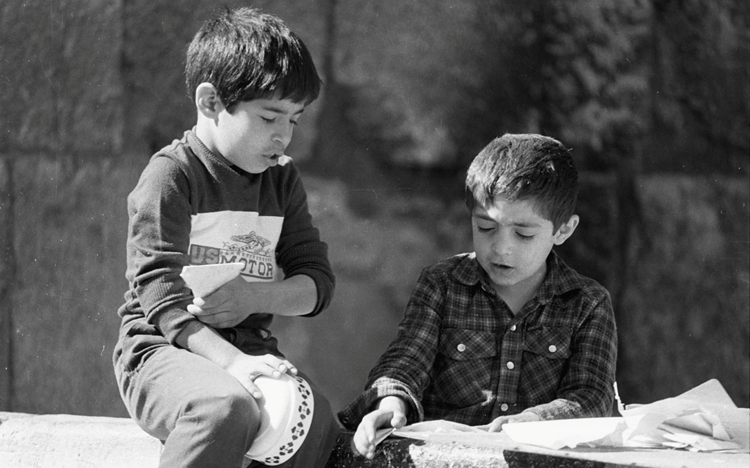 طفل في دمشق القديمة يصنع زوارق من ورق عام 1987م (1)